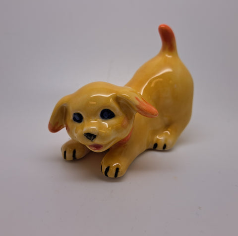 Yellow crouching ceramic dog