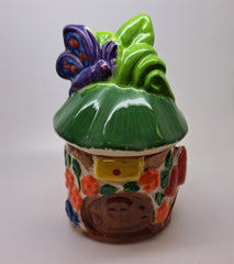 Ceramic toadstool house pot with purple butterfly and lid.